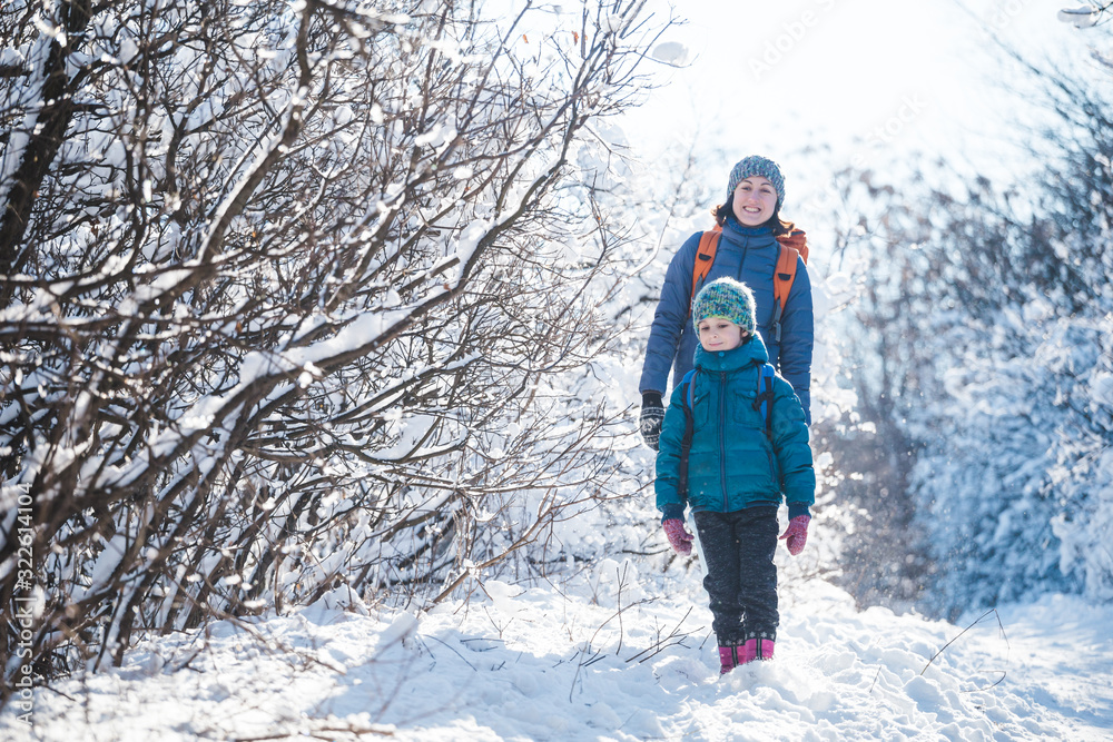 Woman with a child on a winter hike in the mountains.