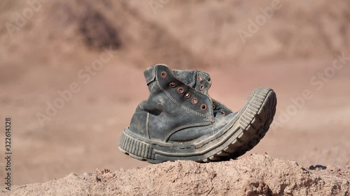 Old black boot in desert photo