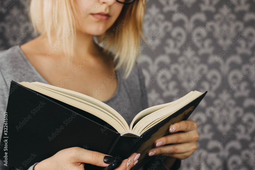 blonde girl in glasses reads an open book, cropped photo blonde girl in glasses reads an open book, cropped photo