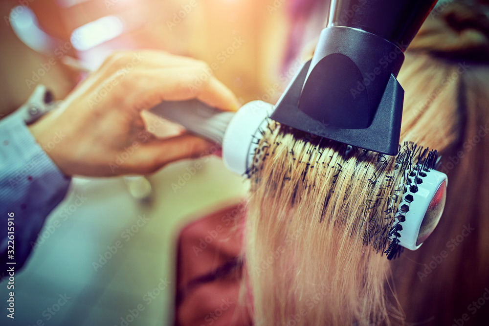 Hairdresser styling hair dryer in a beauty salon Hairdresser styling hair dryer in a beauty salon