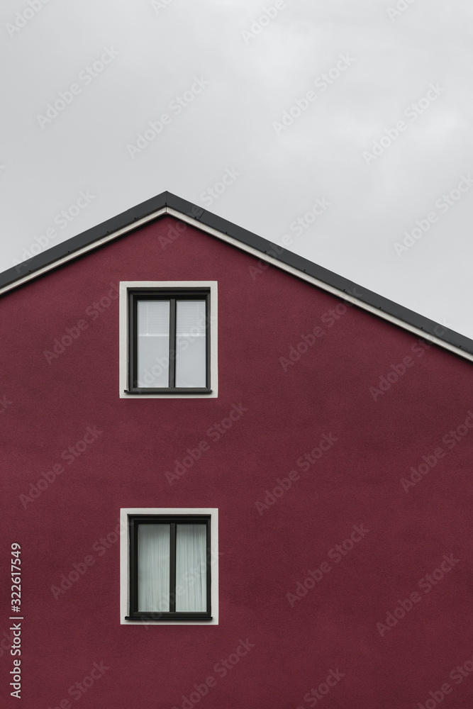 Facade and roof of a dark red house