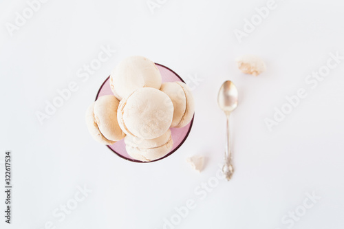 Tasty marshmallows in a violet vase and spoon.White background.Minimalism.Top view