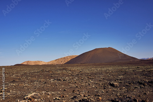 volcanic rocks near the Timanfaya National Park against cloudless blue sky in Lanzarote, Canary Islands