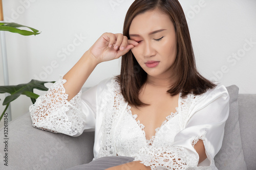 Woman scratch because of itching on the right eyelid photo