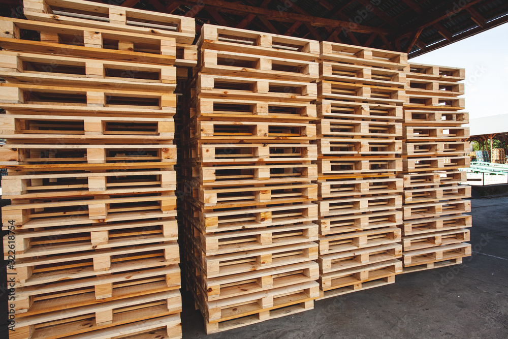 The multiple stacks of wooden pallets in the stock