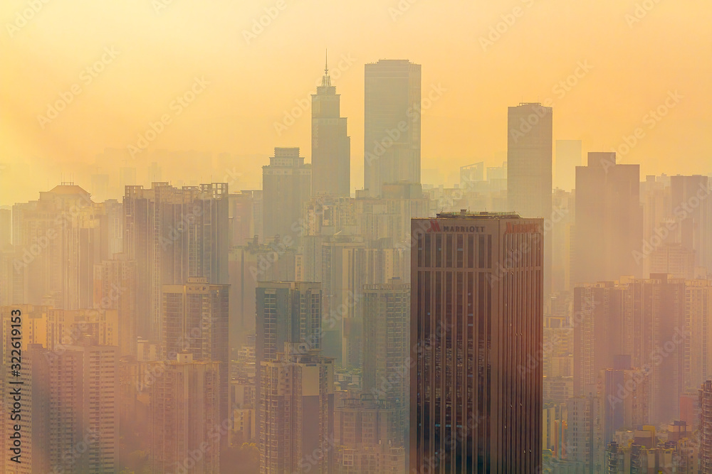 Chongqing, China - March 22, 2018: Blurred cityscape in sunset haze. Marriott Hotel Building in the Chinese city of Chongqing.