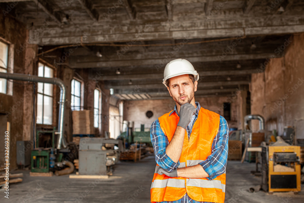 Man standing at the old factory in a protective helmet Man standing at the old factory in a protective helmet