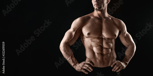 Unrecognizable Strong Athletic Sexy Muscular Man on Black Background.