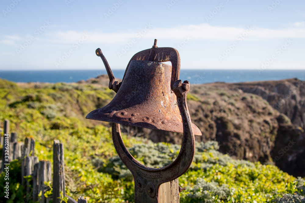 Fototapeta premium Rusty old brass bell by the sea coastline.