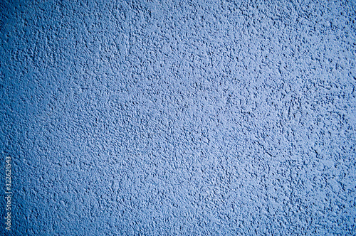 Wall of blue rough embossed building decorative stucco. Texture, background