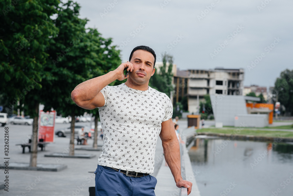 Sports guy stands and talks on the phone. Lifestyle