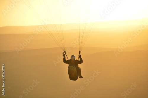 Paraglider flying in a spectacular sunset