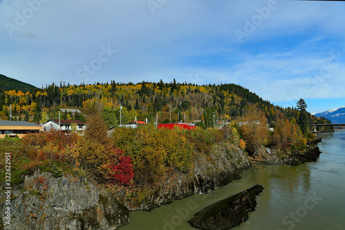 Trees and village on the rocky banks of a river photo
