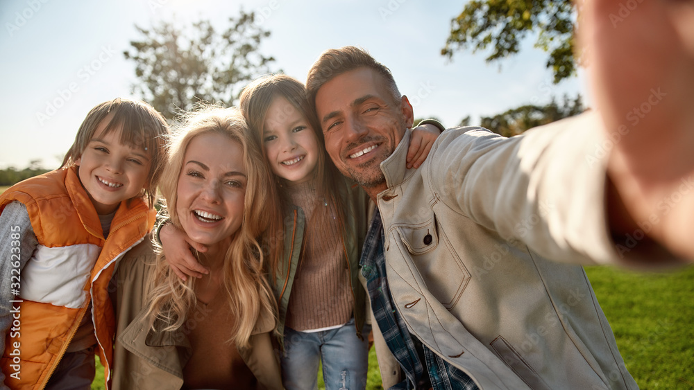 Everybody is smiling right now. Happy family taking selfies outdoors Everybody is smiling right now. Happy family taking selfies outdoors