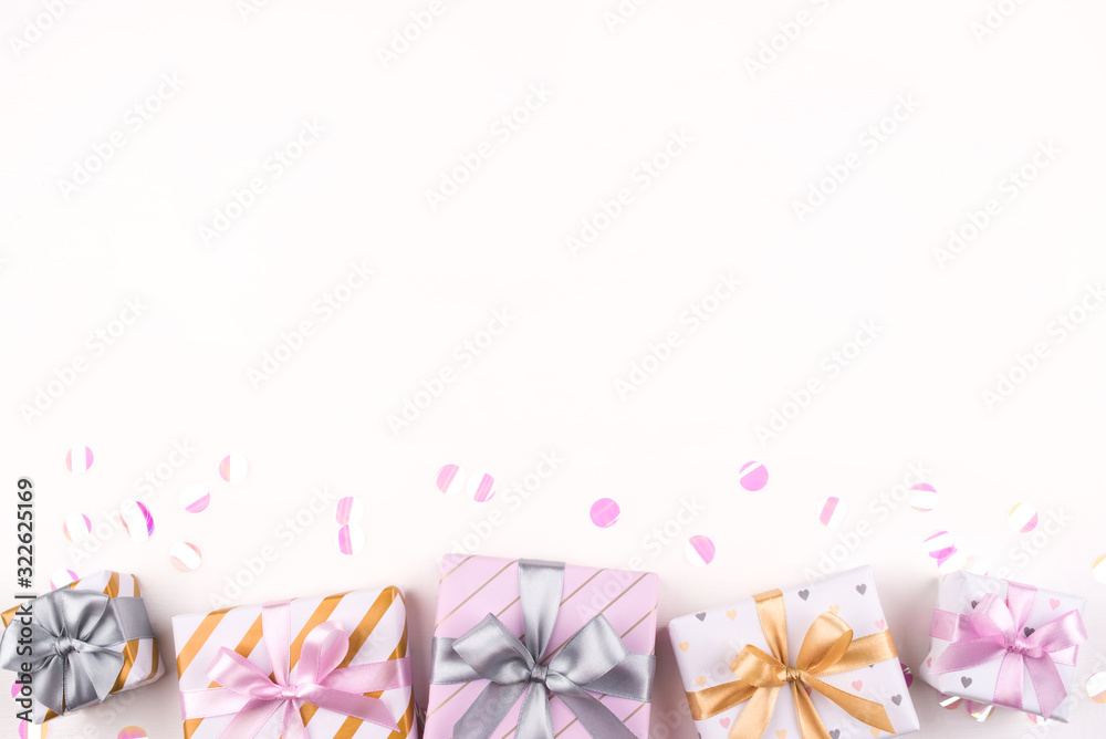 Set of gift boxes with bows and confetti on a white background. Flat lay composition. Birthday, christmas, wedding or another holiday concept.