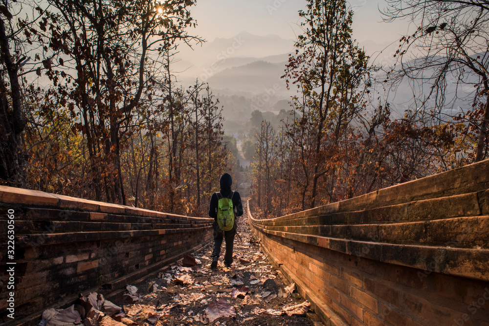 A young woman climbing the stairway leading to Wat Phra Non temple in Mae Hong Son, Thailand. A young woman climbing the stairway leading to Wat Phra Non temple in Mae Hong Son, Thailand.
