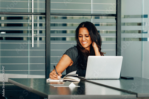 Woman taking notes on conference call