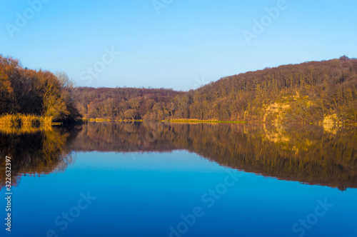Autumn landscape. The lake reflects the autumn forest.