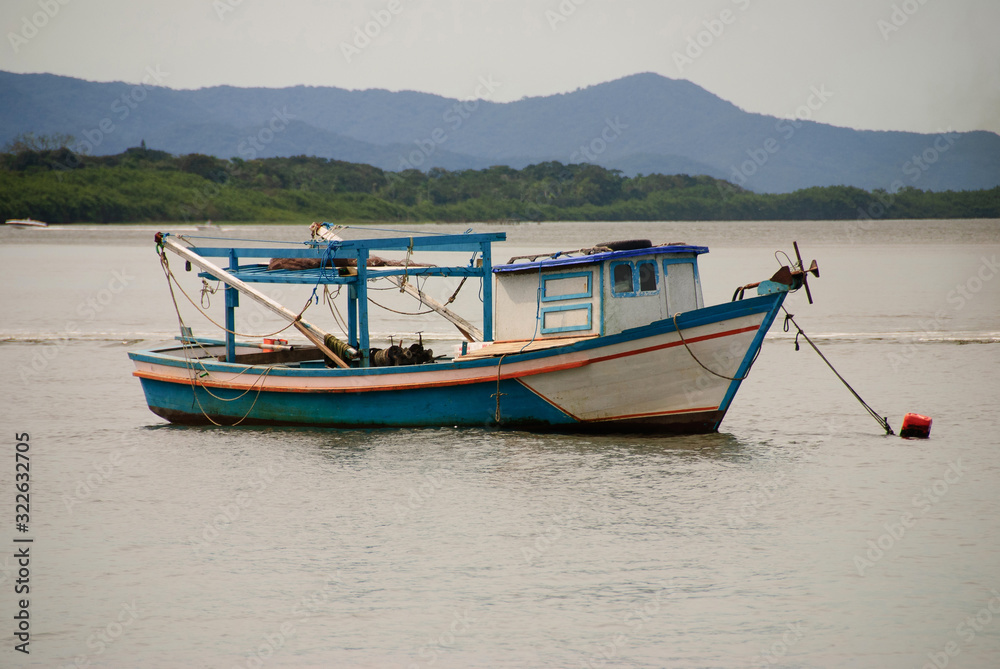 hing boats anchored in the river, floating peacefully in harbor.