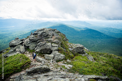 Male hiker heading down through the mountains with lush green colors