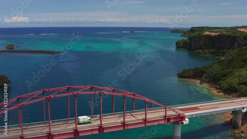 Aerial drone shot of the red Miyagi bridge Ikei island Okinawa Japan. Ikeijima coral tropical waters and coastline. photo