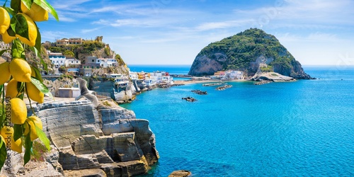 Rocky coast of Sant'Angelo, giant green rock in blue sea near Ischia Island, Italy. Sant'Angelo is small village within comune of Serrara Fontana, Ischia.
