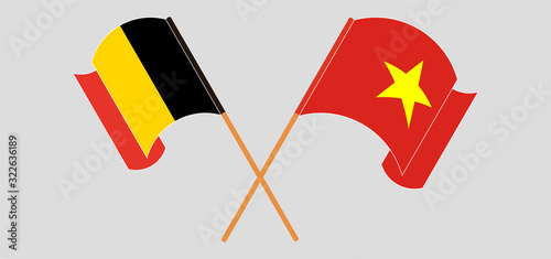 Crossed and waving flags of Belgium and Vietnam