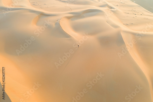 Aerial view of a man walking on sand dunes Eastern Mahadir, Abu Dhabi, United Arab Emirates photo