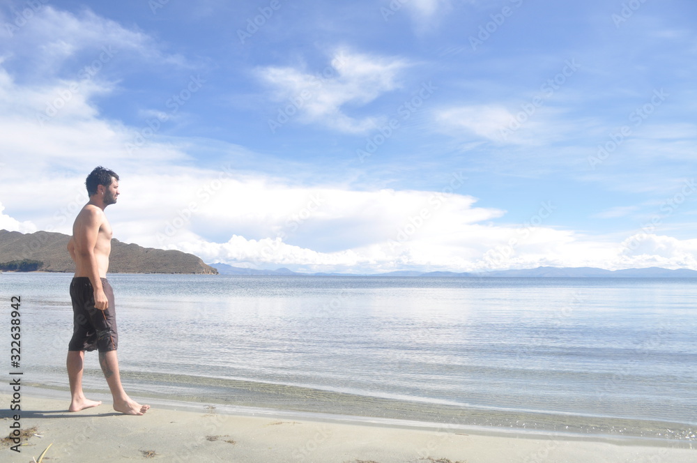 Young man in swimming trunks on a paradise beach