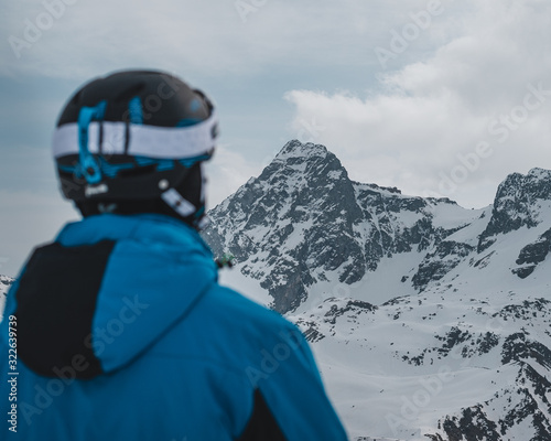 persona mirando hacia la nada en la montaña en invierno. La persona lleva equipo de esquiar en un ambiento nevado i con un sentimiento helado