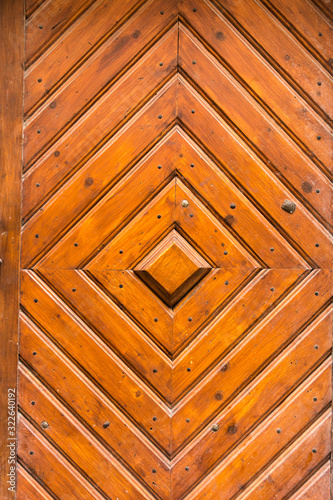 Old wooden door. Wooden brown planks are filled in the form of a rhombus.