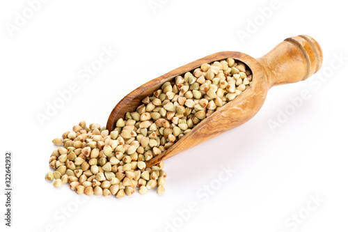 Raw buckwheat and wooden spoon on white background.