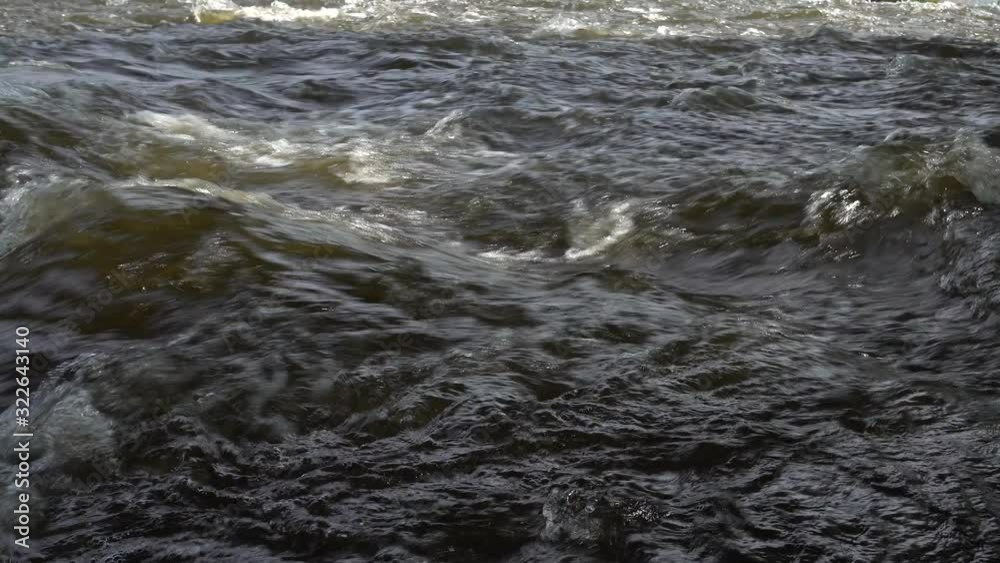 Strong water stream flows across the stones, close up. River rapids. 4K stock video footage Strong water stream flows across the stones, close up. River rapids. 4K stock video footage