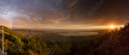 panorama Gelendzhik Bay at sunset. the photo was taken from a height of the mountain. in the foreground, the Caucasus mountains. on the right, the sun sets, clouds. a small rainbow on the left
