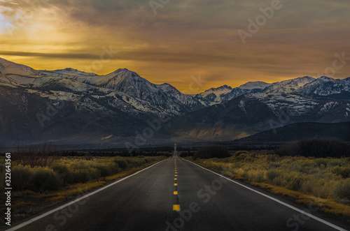Road image with snowy mountains at sunset