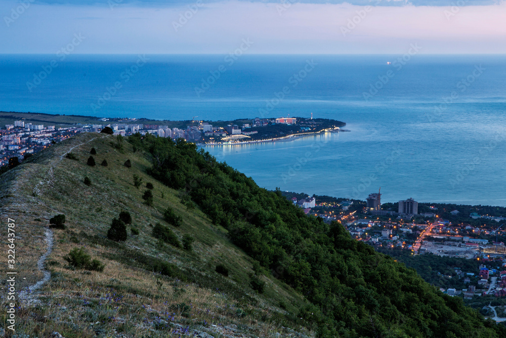 Gelendzhik Bay, Thick Cape and Gelendzhik lighthouse in the evening twilight from a bird's eye view.  lights of the embankment are reflected in the Bay.