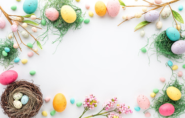 Top down view of an Easter border frame of robin's eggs and chocolate eggs with copy space in the middle