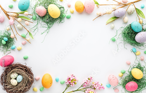 Top down view of an Easter border frame of robin's eggs and chocolate eggs with copy space in the middle