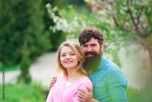 Spring couple laughing and hugging. Loving man and woman on a walk in a spring blooming park.