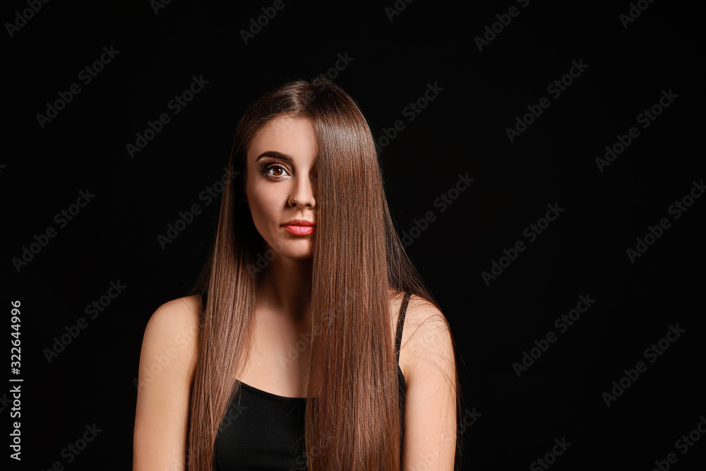 Beautiful woman with healthy long hair on dark background Beautiful woman with healthy long hair on dark background