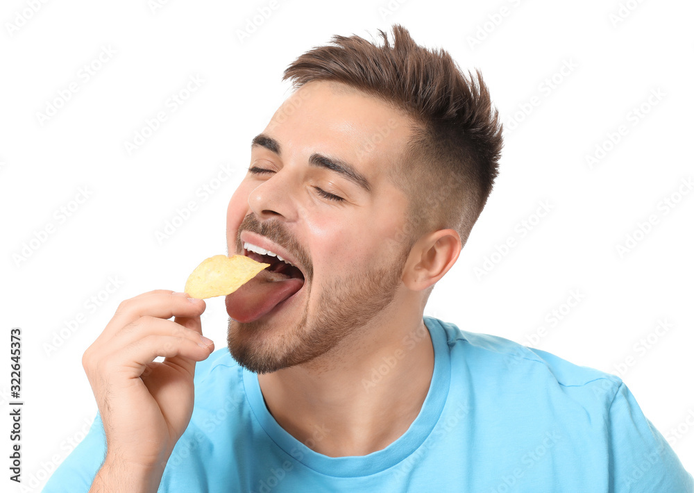 Handsome young man eating tasty potato chips on white background Handsome young man eating tasty potato chips on white background