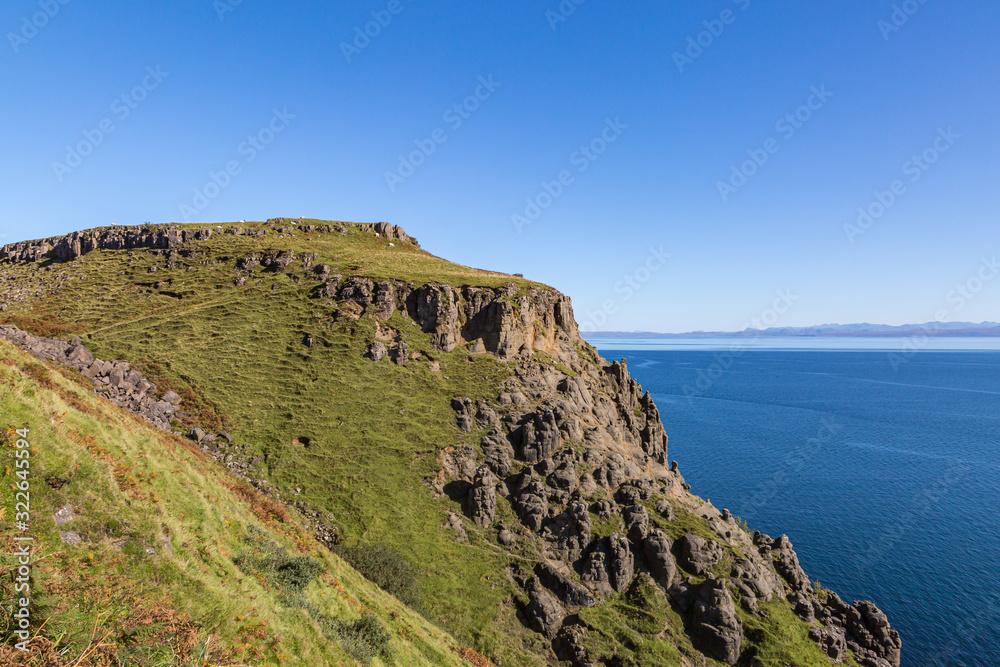 The rugged coastline of the Isle of Skye with a clear blue sky overhead