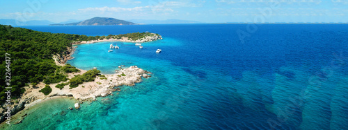 Fototapeta Naklejka Na Ścianę i Meble -  Aerial drone ultra wide photo of paradise small island of Moni visited by sail boats and yachts with turquoise clear seascape, Aegina island, Saronic gulf, Greece