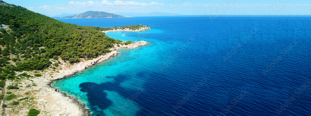 Naklejka premium Aerial drone ultra wide photo of paradise small island of Moni visited by sail boats and yachts with turquoise clear seascape, Aegina island, Saronic gulf, Greece