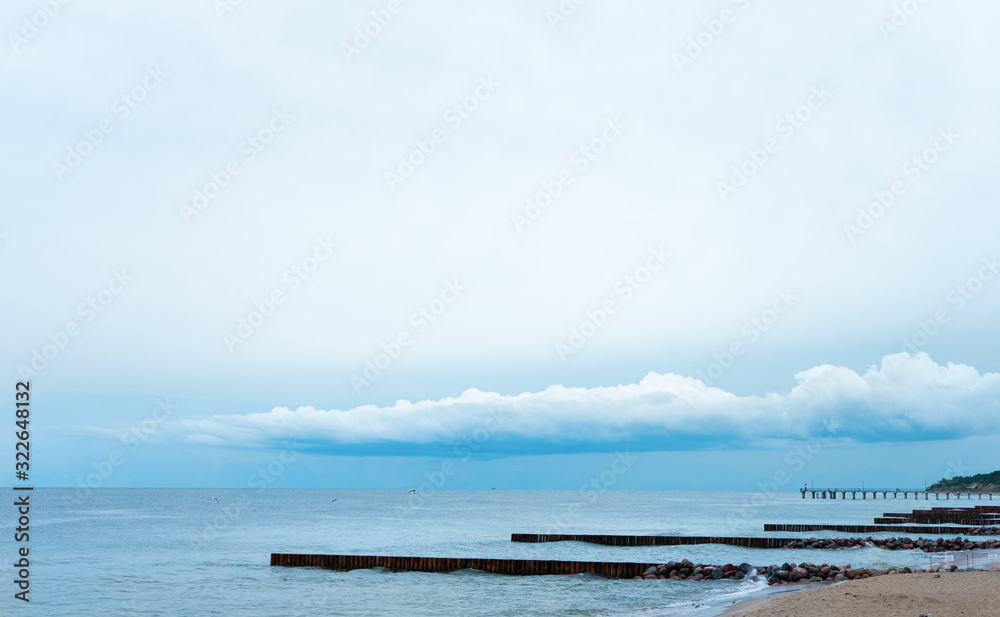 landscape, the blue sky with low clouds merges with the blue sea with breakwaters. can be used as background. concept of serenity, calm