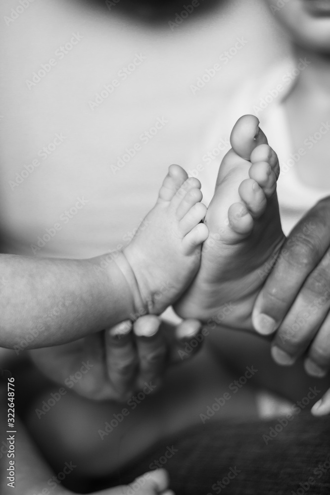 Dad holds in his hands the legs of his little sons. a family. the details. Dad holds in his hands the legs of his little sons. a family. the details.