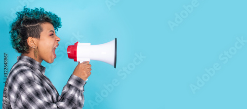 african american girl or woman with megaphone isolated on blue background