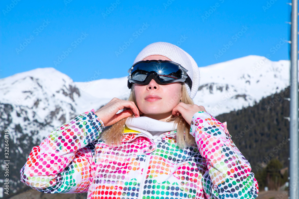 beautiful girl in the snow in the mountains in ski outfit
