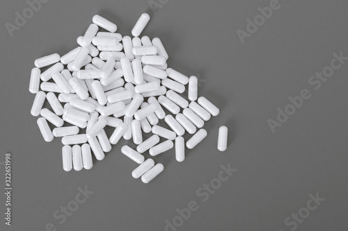 White pills on the grey paper background