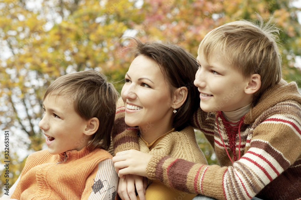 Fototapeta premium Happy mother and sons in the autumn park